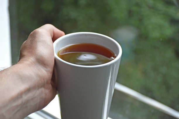 茶喝。男人手里拿着一杯热茶或咖啡图片下载