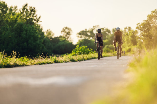一对情侣在外面骑着自行车，戴着头盔和太阳镜图片下载