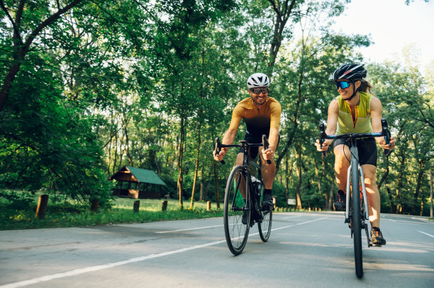 一对情侣在外面骑着自行车，戴着头盔和太阳镜图片下载