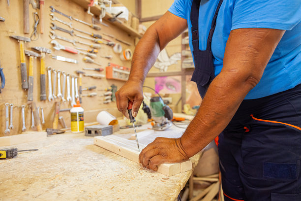 印度木匠在他的木工房里使用螺丝刀。图片下载