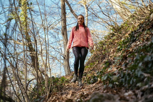 美丽快乐的女孩徒步旅行，穿过森林图片下载