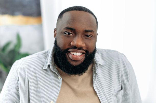 特写照片积极自信英俊成功的非裔美国年轻人在时尚的休闲装，男性自由职业者，执行，产品经理，看着相机，微笑友好图片下载