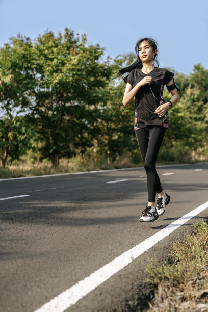 妇女在马路上跑步锻炼身体。图片下载
