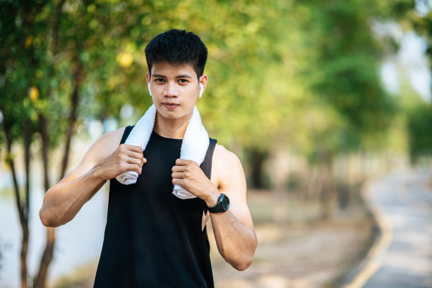 一个穿黑衬衫的男人站在那里，用手帕捂着脖子擦脸。图片下载