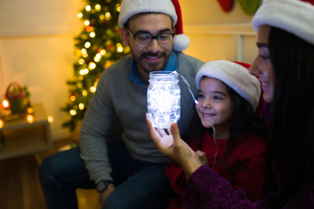 有趣的父母和小女孩看着圣诞彩灯图片下载