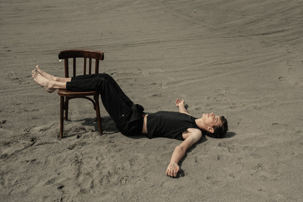 沙漠中躺在椅子上的孤独男子图片下载