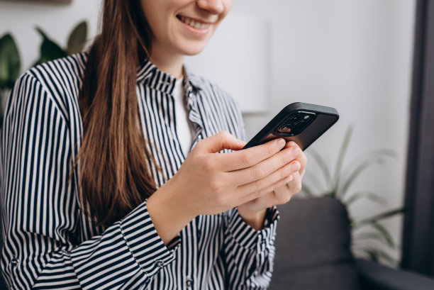 特写的快乐微笑的年轻白人女性在家里或智能办公室使用智能手机，积极的女孩使用手机和短信。技术，创业，新业务和沟通理念图片下载