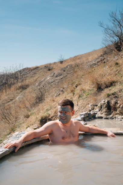 一名脸上涂着治愈粘土的男子正在硫化氢温泉中沐浴。图片下载