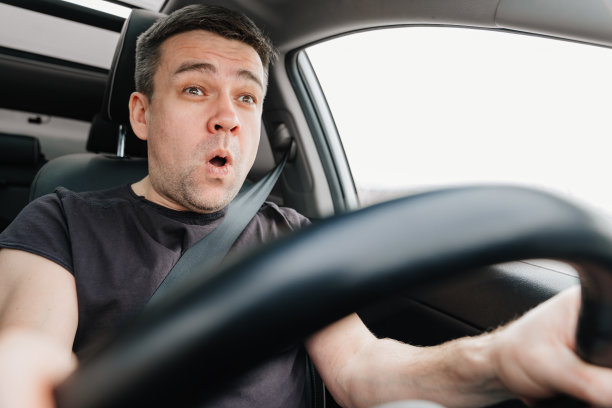 一个吓坏了的人在高速公路上开车。路上发生了一起危险的事故。图片下载