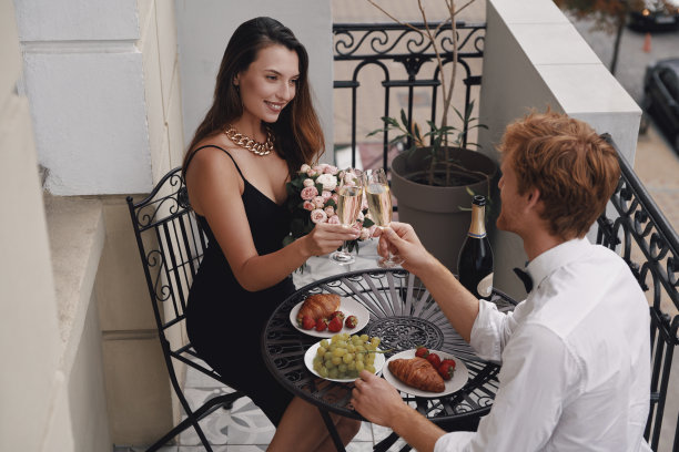 俯瞰年轻夫妇在阳台上喝着香槟，吃着浪漫的晚餐图片下载