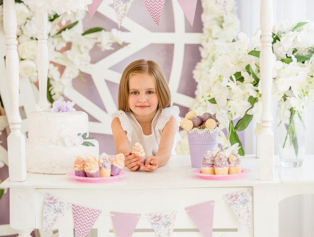 小女孩在糖果棒里拿着一个甜蛋糕图片下载