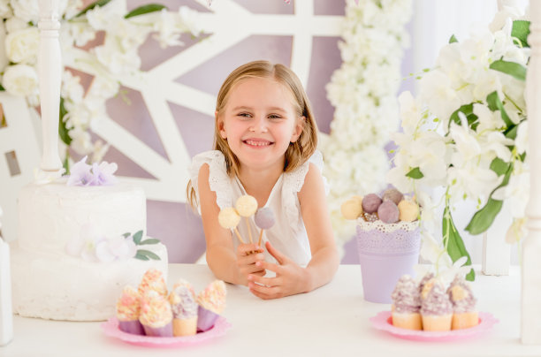 小女孩拿着五颜六色的棒棒糖在糖果棒里图片下载