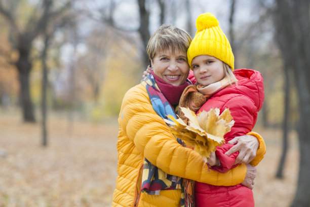 奶奶和小孙女一起在秋天的公园散步，玩得很开心。幸福的一家人在户外野餐。图片下载