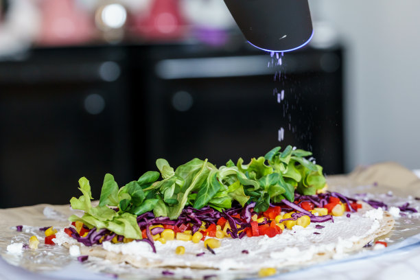 一位厨师正在往玉米饼上撒盐。图片下载