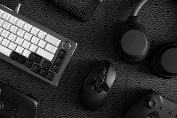 玩家工作空间的概念，俯视图一个游戏装备，鼠标，键盘，操纵杆，耳机，手机操纵杆，耳机和鼠标垫在黑色桌面背景上。图片下载