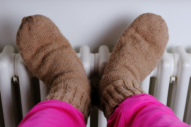 孩子的脚在温暖的羊毛袜子上的电池图片下载