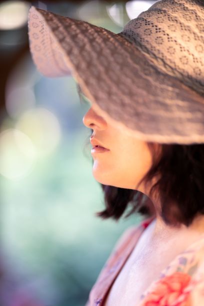 迷人的年轻女子戴着一顶夏天的帽子，背景模糊图片下载