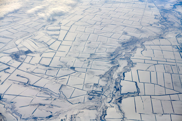 空中云景观在云顶到雪覆盖的河流，道路，城市和田野，冬天的空气图片下载