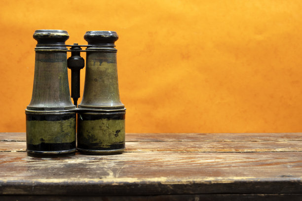 哥伦布发现美洲纪念日的概念。木桌上的老式军用双筒望远镜，发现设备图片下载