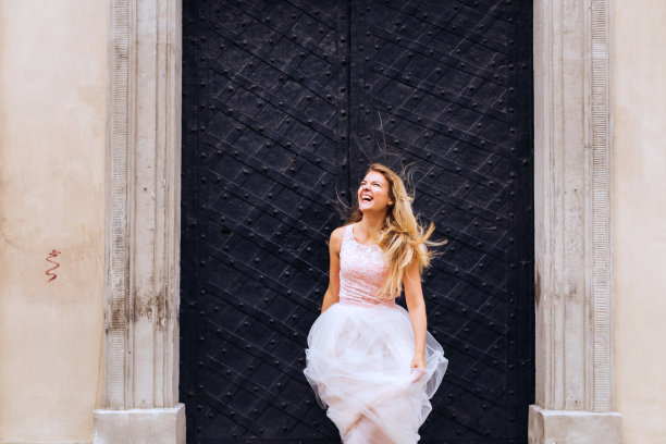 新娘真诚地微笑着，把婚纱抱在怀里。成矿图片下载