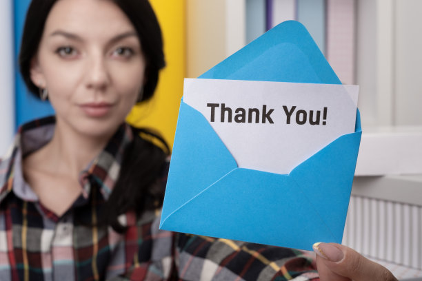 女士展示信封里的感谢卡片。善良的行为图片下载