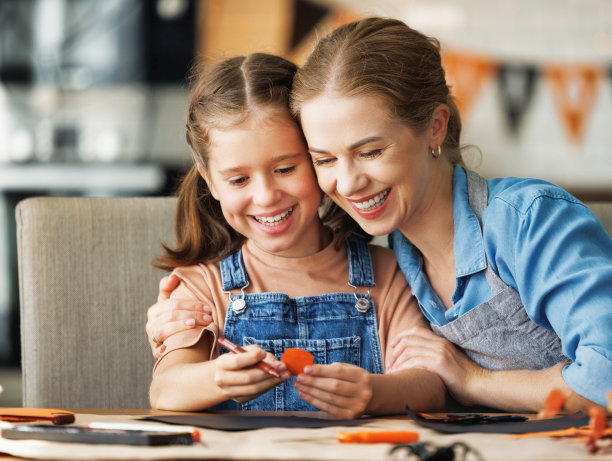幸福微笑的家庭母亲和女儿一起做万圣节的家庭装饰图片下载