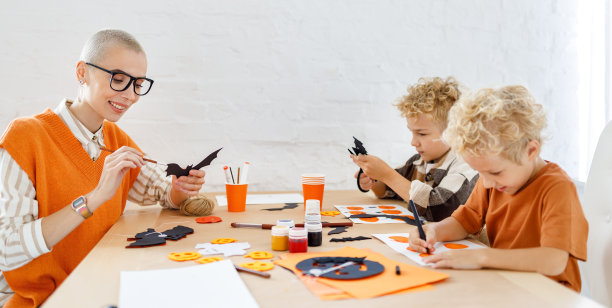 年轻的家庭母亲和孩子们准备万圣节的装饰图片下载