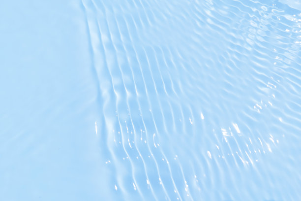 离焦模糊透明的蓝色清澈平静的水面纹理带有水花、气泡。粼粼碧水涟漪背景。游泳池的水面。蓝色的泡泡水闪闪发光。图片下载