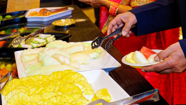 人们在自助排队时把食物放在盘子里图片下载