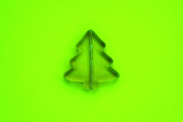 圣诞作文由小塑料松树霓虹绿色的背景。节日、冬季和庆祝的概念图片下载