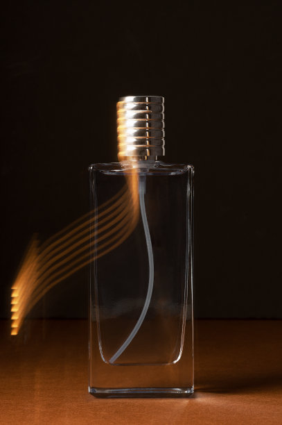 香水在喷雾瓶和灯光闪光在黑暗的工作室图片下载
