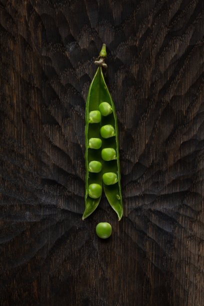 新鲜的绿色豌豆荚在木制背景。图片下载