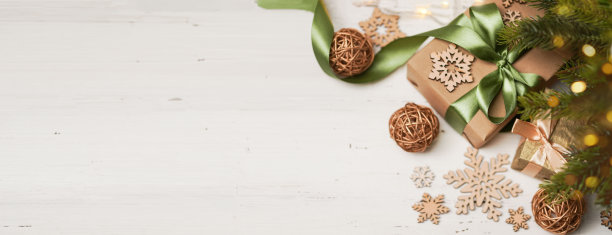 生态圣诞假期背景。圣诞树，手工纸礼品盒，礼物，木制装饰。圣诞灯。横幅。图片下载