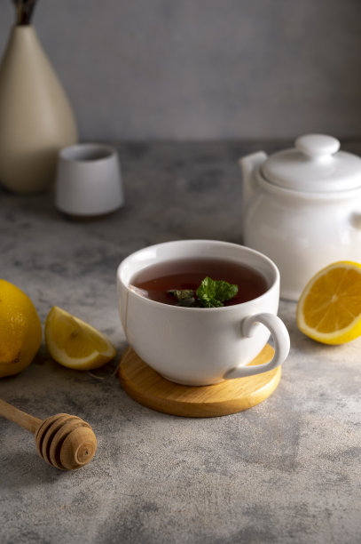 用白色陶瓷杯装的茶，加柠檬、蜂蜜和薄荷叶。生活方式温暖的饮料。放松的概念。图片下载