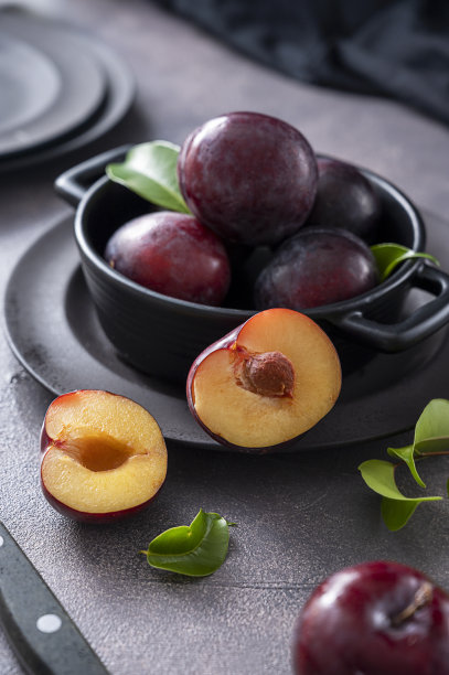 新鲜的樱桃梅子在黑色的碗里，黑暗和忧郁的食物照片图片下载