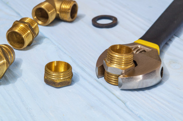 黄铜配件和可调节扳手在蓝板特写图片下载