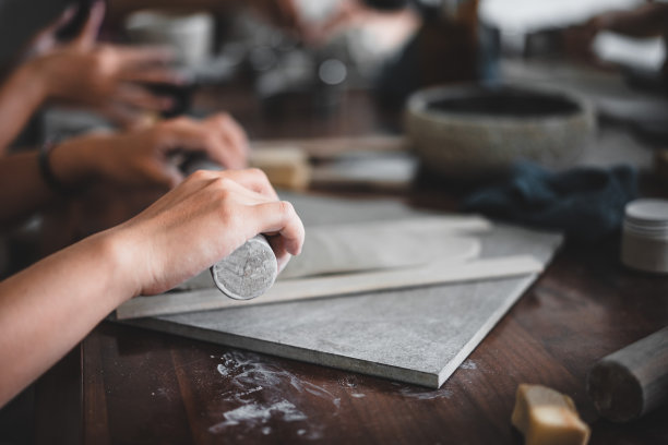 观女手作品用陶土制作未来陶瓷板，陶瓷艺术家在现代陶艺作坊制作班手建筑，创意人士手工设计图片下载