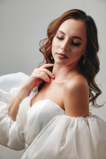 画像时尚的新娘年轻女子在白色婚纱站在镜子前，闭着眼睛。新娘女士在复古的房间，灰色的墙背景在工作室。时尚风格的概念。复制文本空间图片下载