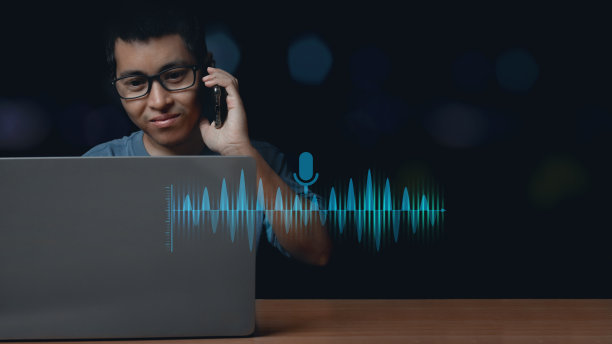 年轻人使用笔记本电脑和使用语音助手与智能手机通话以获取信息。图片下载