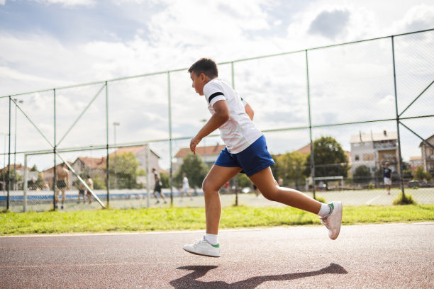 男孩在城市的跑道上跑步。图片下载