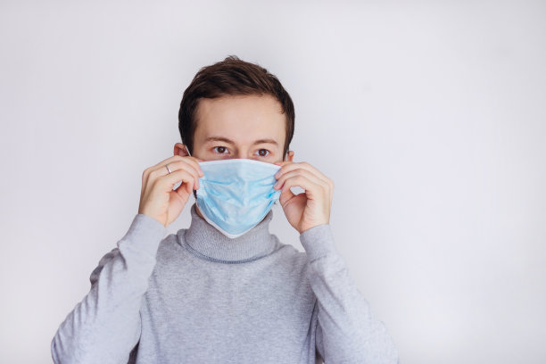 新冠肺炎疫情防控肖像。戴着防护口罩的大胡子男子因新冠病毒病症状发烧。图片下载