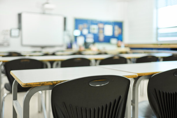 学生们在学校的教室里一排排地坐着桌椅图片下载