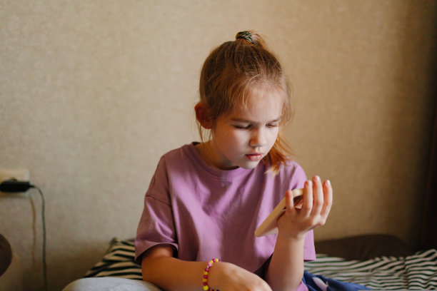 一个小女孩正在上网玩手机上的应用程序。图片下载