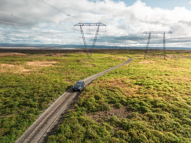 在输电线维修道路上行驶的汽车鸟瞰图图片下载