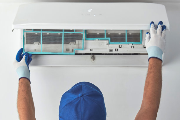 维修人员清洁和固定室内交流机组。图片下载