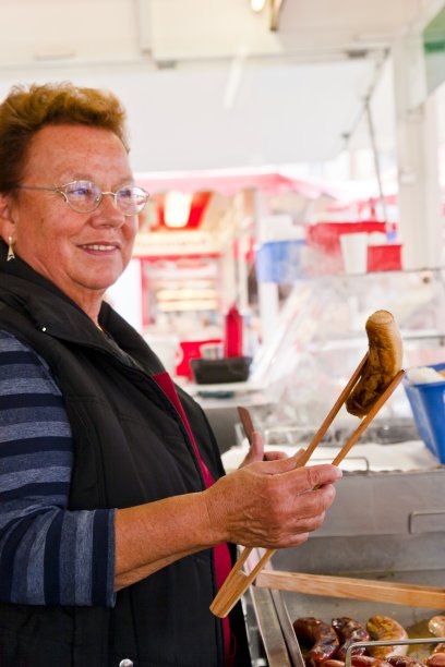 老妇人在她的小吃摊上卖小香肠图片下载