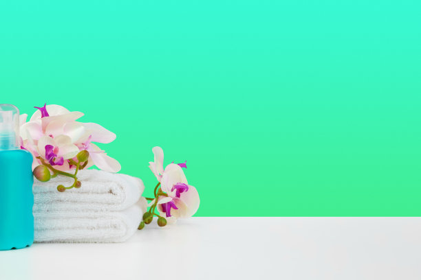 美丽的粉色花朵和粉色背景上的白色毛巾图片下载