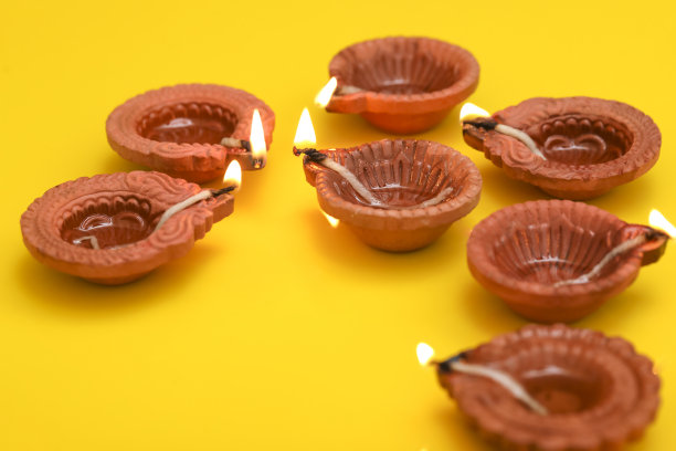 印度排灯节的概念。黄色背景的传统油灯。图片下载