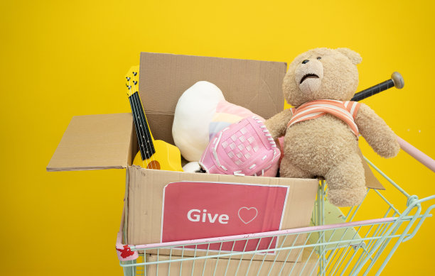 盒子里装满了捐赠用过的玩具、衣服、书籍和文具。捐赠给有需要的人，温暖的婴儿衣服和玩具装在纸板箱里，捐赠给儿童。图片下载