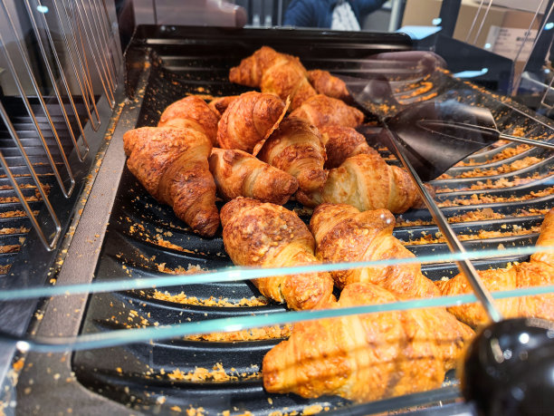 新鲜的奶酪羊角面包躺在超市的自助货架上，随时准备出售图片下载